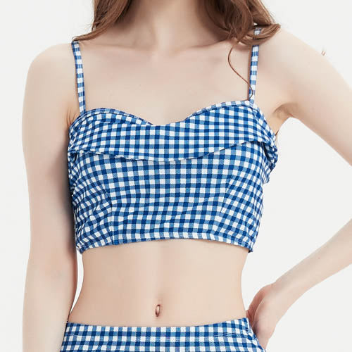 一位女士穿著藍色-MIX&MATCH泳衣上身 <23551695>細肩帶Crop上衣,搭配同色系下身,單手叉腰站立在素色背景中。.