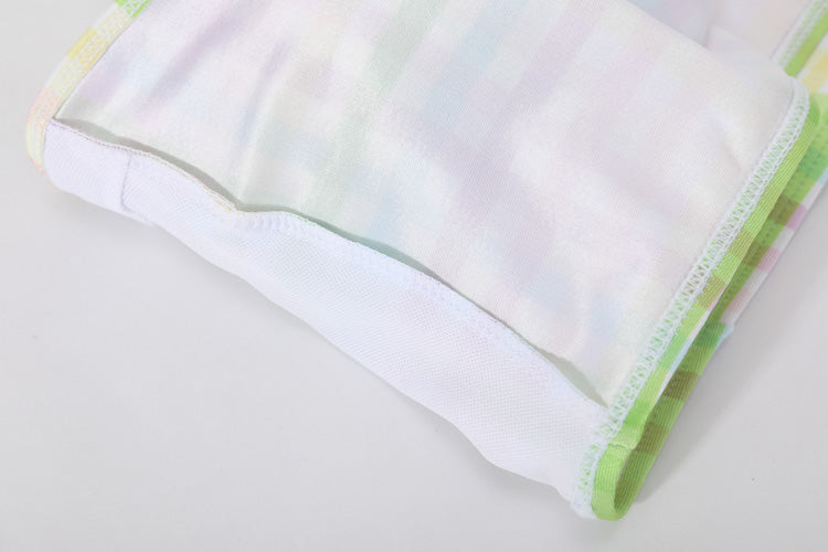 白色背景上的柔軟粉彩布料特寫,飾邊為淺綠色,縫線整齊,類似彩色格紋-MIX&MATCH泳衣上身 <23551696>的柔和色調。.