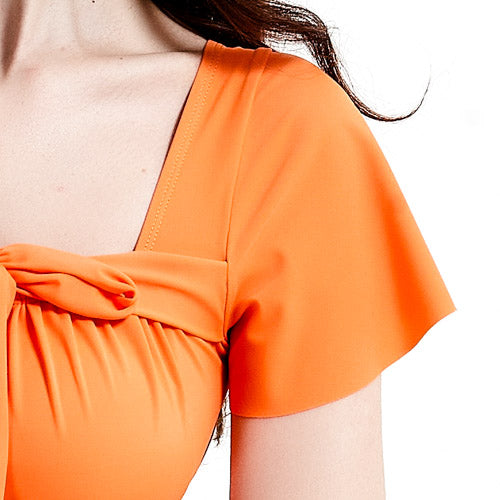 身穿 橙色背心 MIX&MATCH 泳衣上身 <23641739> 的女性特寫,在白色背景下只露出肩膀、上胸部和部分頭髮。.