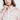 一位女性穿著粉紅色超薄防風外套 <20121817-110>，胸前有細緻的粉紅色花卉印花和小圖案，觸碰她的脖子。圖片在她的額頭和軀幹中部被剪裁。.