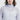 A woman wears a pink紫色超薄防風外套〈20121817-50〉with 連帽設計 and胸前簡約logo, standing against a plain white background.超輕薄材質帶來全天舒適和時尚感。.