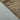 春秋穿著的兩種布料紋理特寫：一種是平滑的淺灰色；另一種來自天藍色 2合1撥水防風外套 <20621677-40>，金屬金色搭配黑色六角形蜂巢圖案，以對角線分割。.