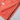 Folded coral-colored jacket on a light gray surface