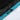 Close-up of a zipper on a black and teal jacket with a white background