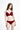 一位留著波浪長髮的女士，身穿酒紅色自然 Push Up MIX&MATCH泳衣上身 <23581697>，微笑著站在純白背景下，身上有 X 型美背設計。.