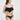 一位身穿 NAMI Bikini 的女性，搭配黑色荷葉邊上衣和 黑色-MIX&MATCH泳衣下身 <24051530>，在素淨的淺色背景下擺姿勢，微微左顧右盼、笑容柔和。.