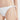 身穿 NAMI Bikini 白色-MIX&MATCH泳衣下身 <24051531>、右側系帶的人物特寫。素色的底色突出了中段和大腿上部，展現出這款時尚的高叉泳衣造型。.