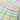 白色高腰裙MIX&MATCH泳衣下身 <24101701>的特寫，以藍、綠、粉紅、黃色的粉色格子圖案為特色，布料上附有一個金色的「nana」小別針。.