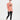 一位身穿桃色東京日本 T 恤和黑色防曬泳衣 <24541449-01> 的年輕男子在白色背景下赤腳行走。.