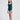 一位波浪狀長髮的女性赤腳站立在純白背景下，身著深藍色收腰裹腹1件頭連身泳衣<21311964>，褶皺細節和寬肩帶。她微微側頭，表情中性。.